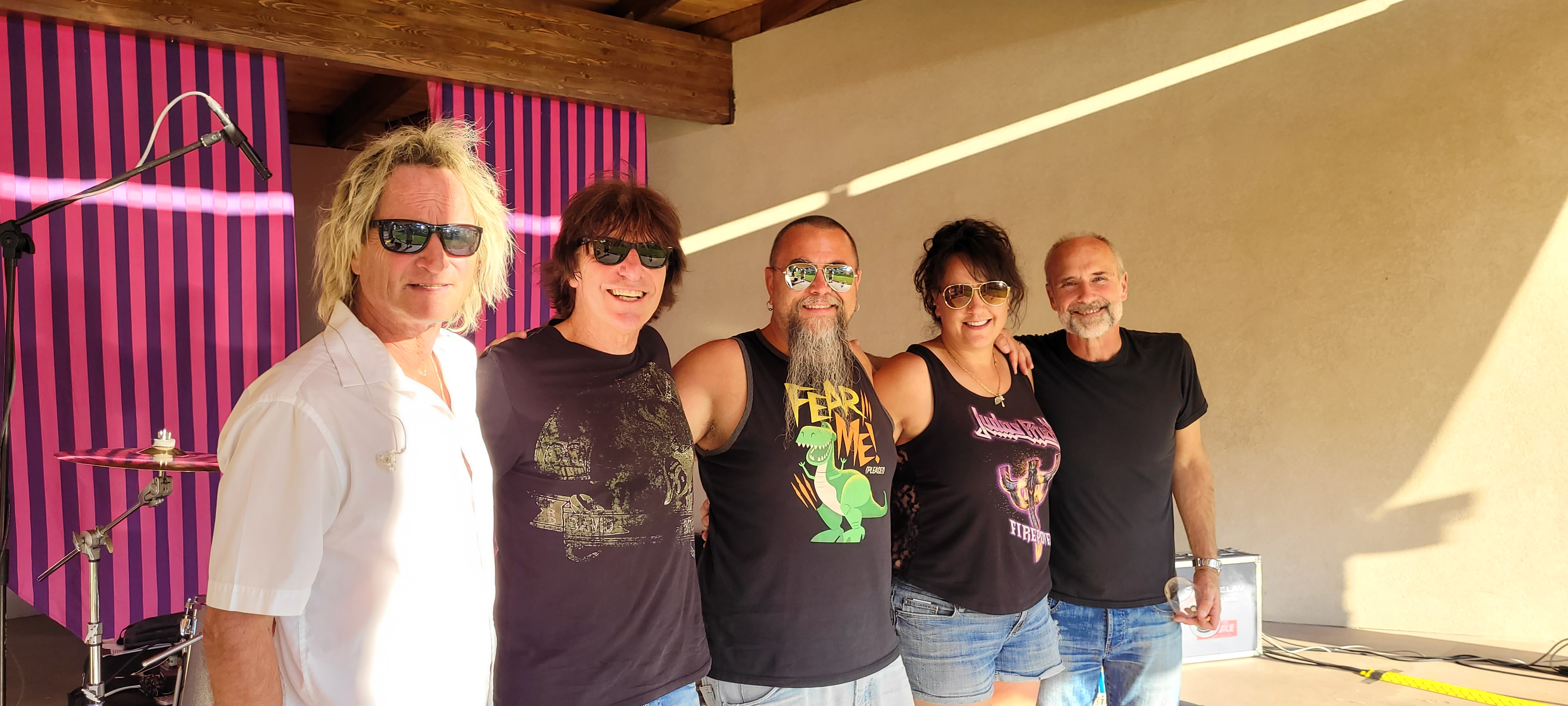 Cease and Desist band members posing together backstage at an outdoor venue