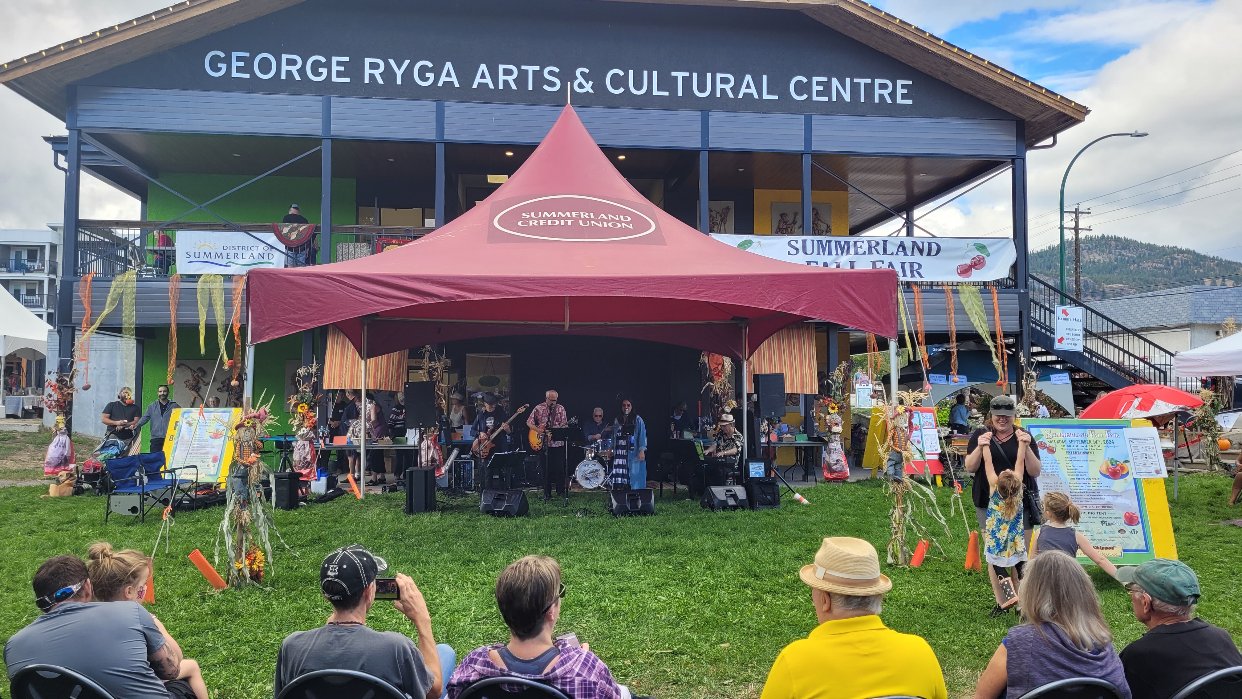 Acoustic band performing under a festival tent at the Summerland Fall Fair